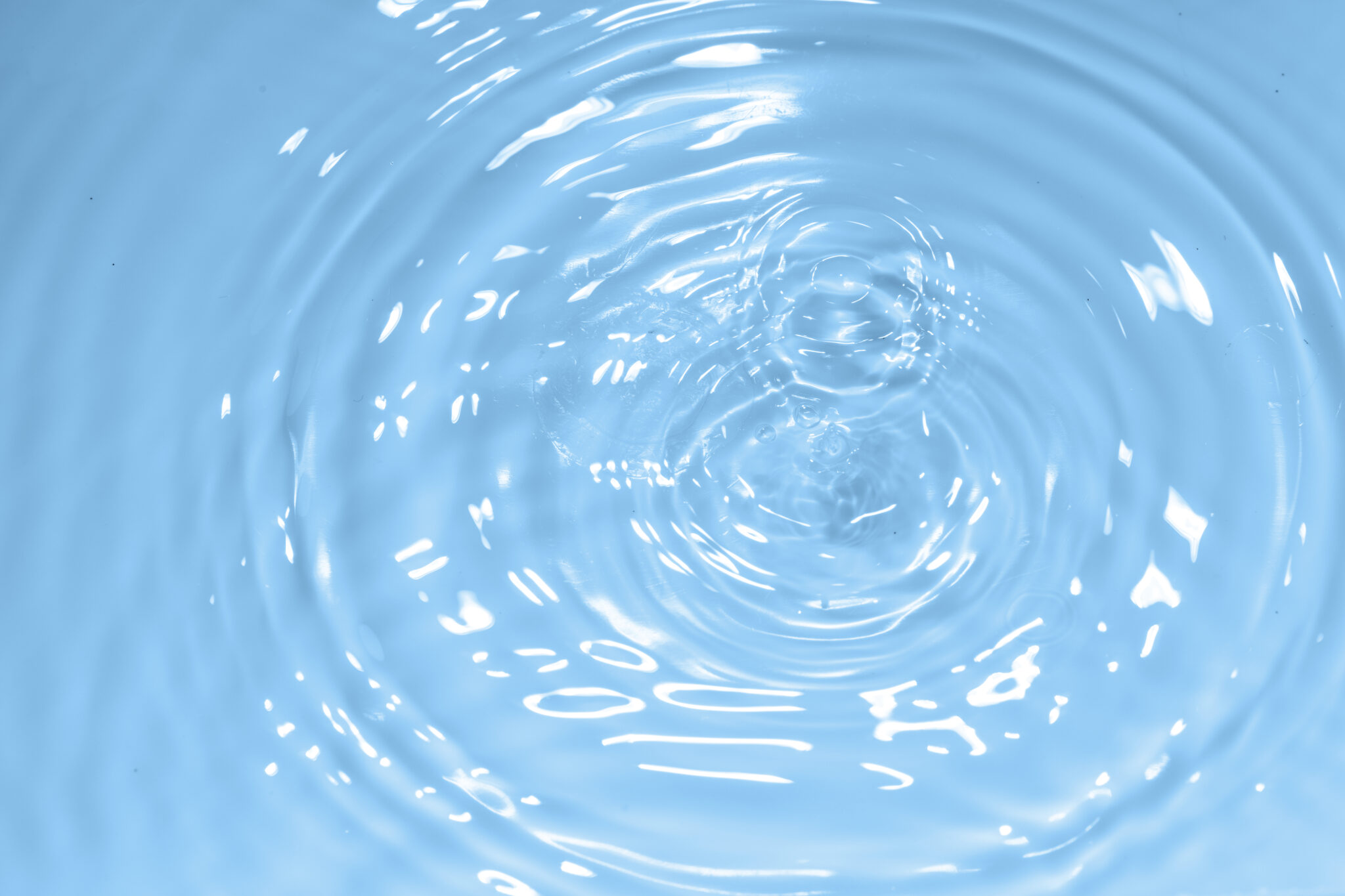 Water drop on clean blue water background